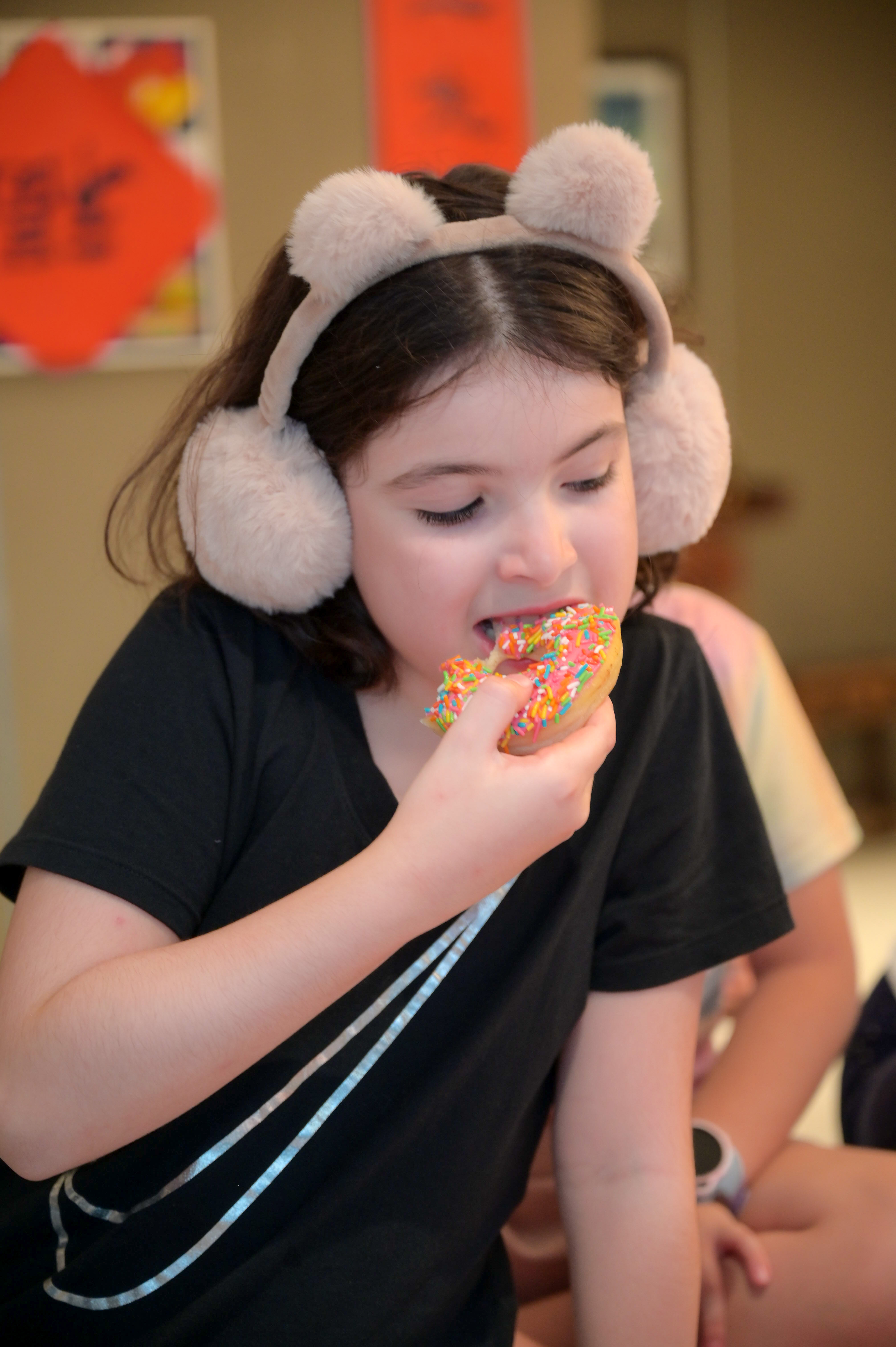 girl eating donut at birthday party Photography